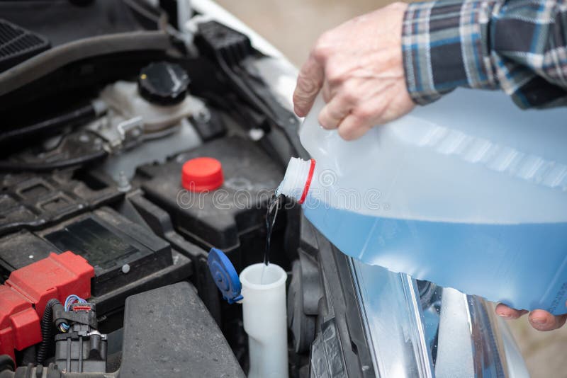 Hands of Mechanic Pouring Windshield Washer Fluid in a Car; Multiple