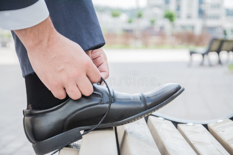 Hands men, groom, businessman tying the laces of his new black leather business shoes, close-up. royalty free stock images Hands men, groom, businessman tying the laces of his new black leather business shoes, close-up. royalty free stock images