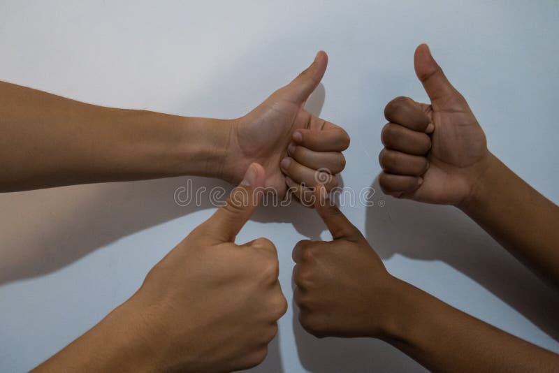 The hands of a multiracial team showing the gesture of the thumb upwards. Concept of diversity royalty free stock image
