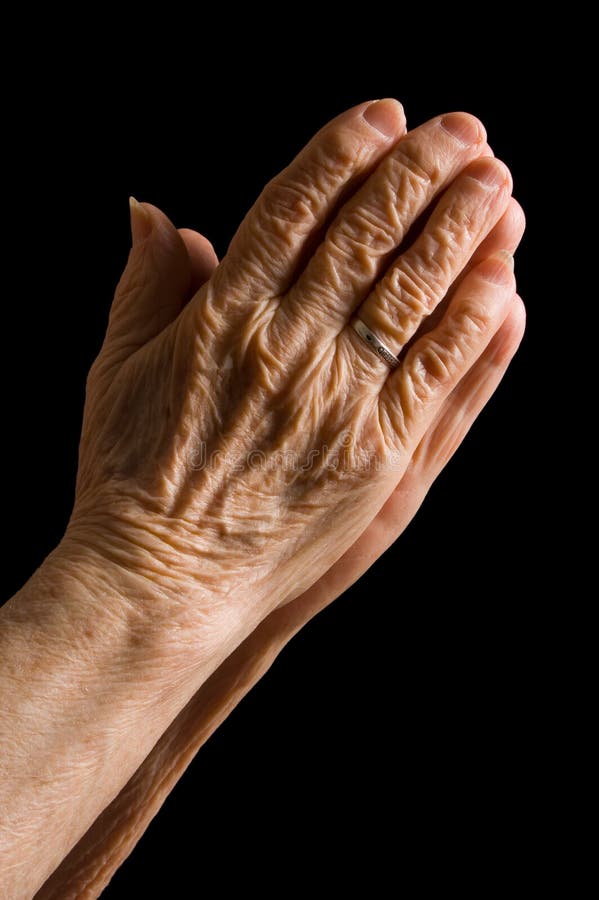 Hands of the old woman on a black