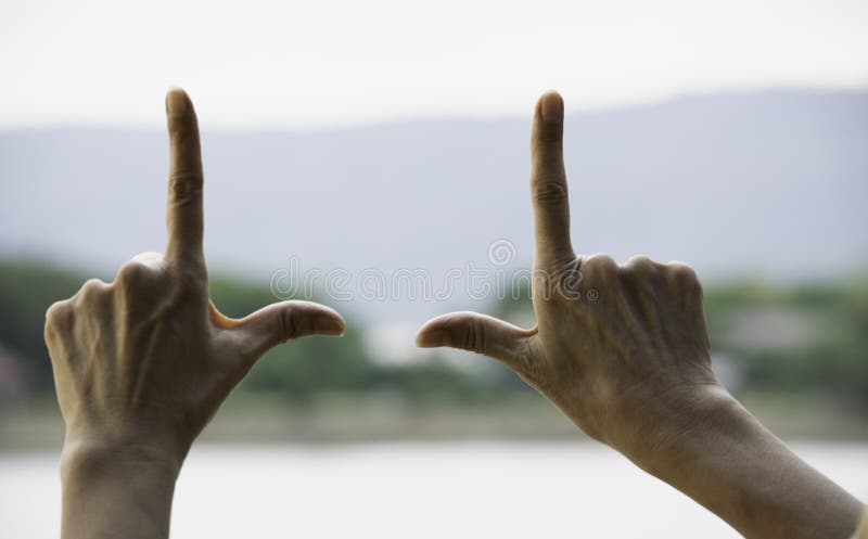 Hands of person making frame distance or symbol in nature.