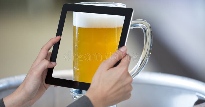 Hands photographing glass of beer through digital tablet at bar royalty free stock images