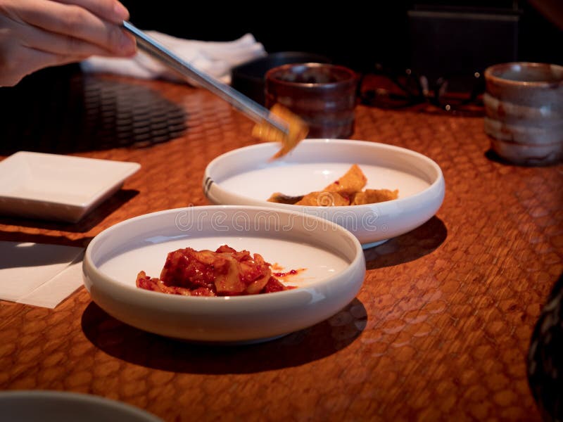 Hands Picking at Side Dishes in a Korean Restaurant Stock Photo Image