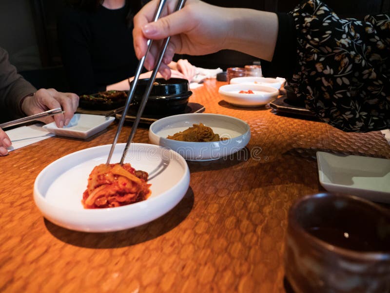 Hands Picking at Side Dishes in a Korean Restaurant Stock Photo Image