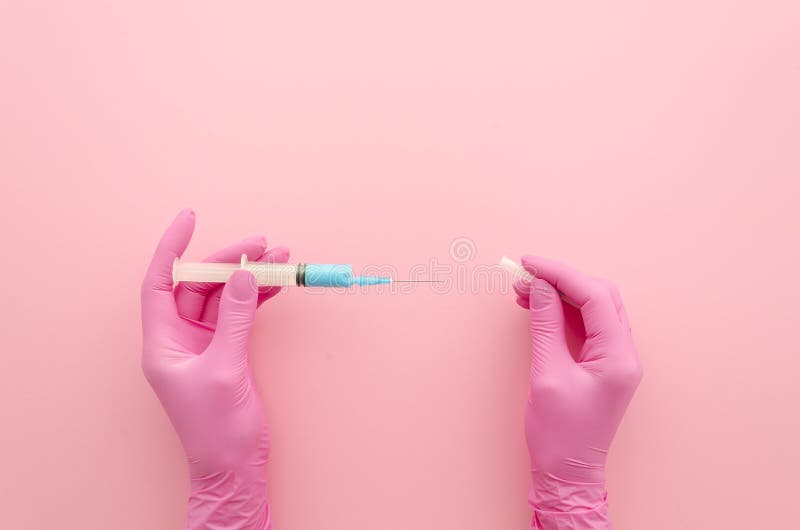 Hands in pink glove with syringe injection on pink. Medical concept. Top view mock up