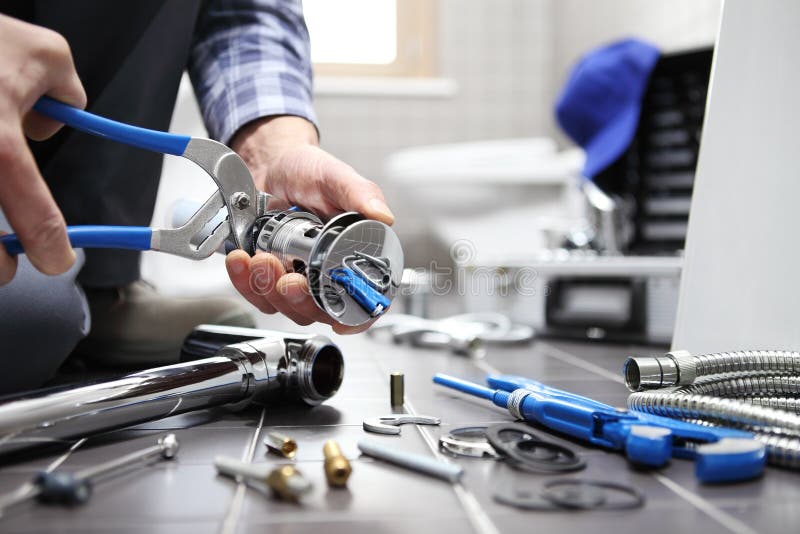 Hands plumber at work in a bathroom, plumbing repair service, as royalty free stock photo Hands plumber at work in a bathroom, plumbing repair service, as royalty free stock photo