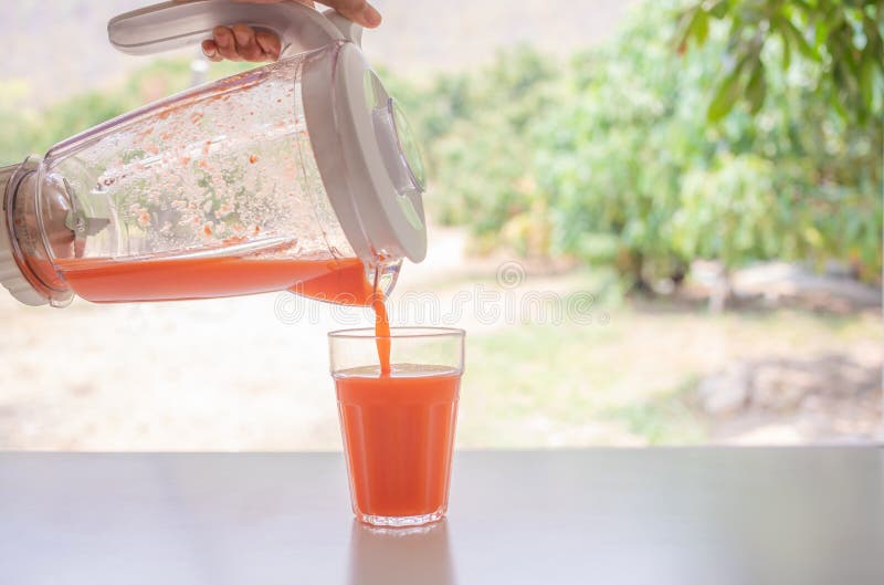 Hands Pour the Blended Carrot Juice into a Glass Copy Space for Your