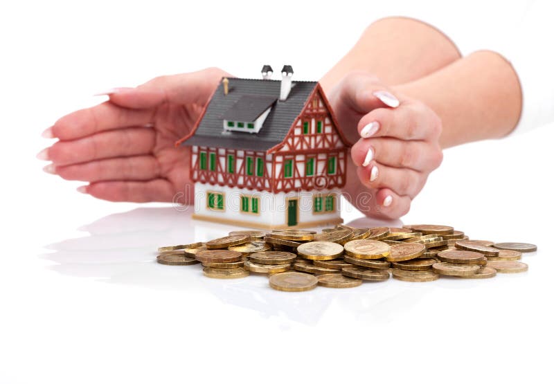 Hands protect miniature house with the coins