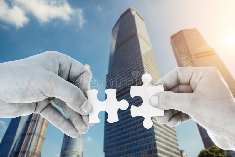 Hands putting partnership puzzle pieces together royalty free stock photo