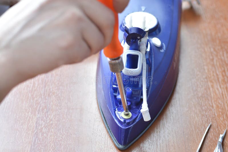 Hands repair iron. Concept: home appliance repair, repair services, home master. Digital system concept stock images, royalty-free photos and pictures