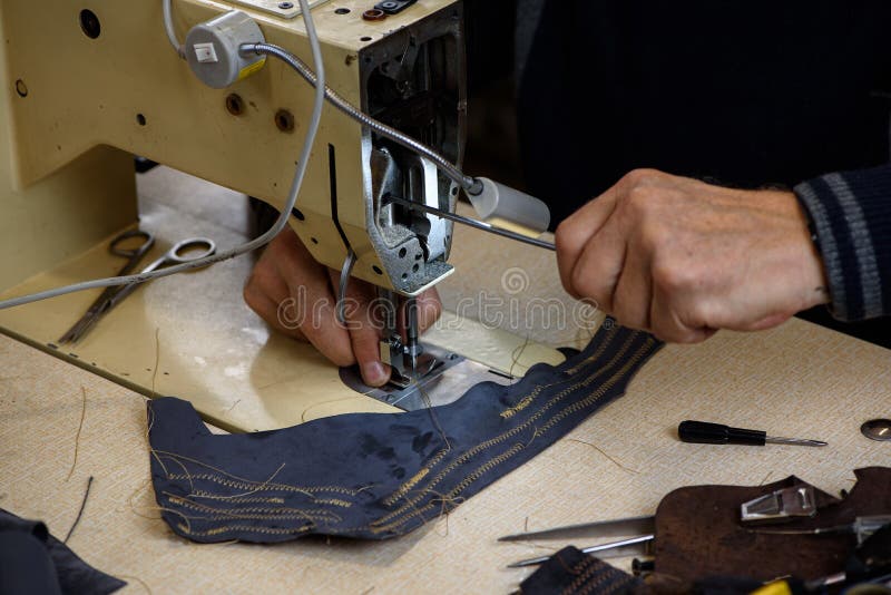 Hands of Repairman Fixing Problems with Professional Industrial Sewing