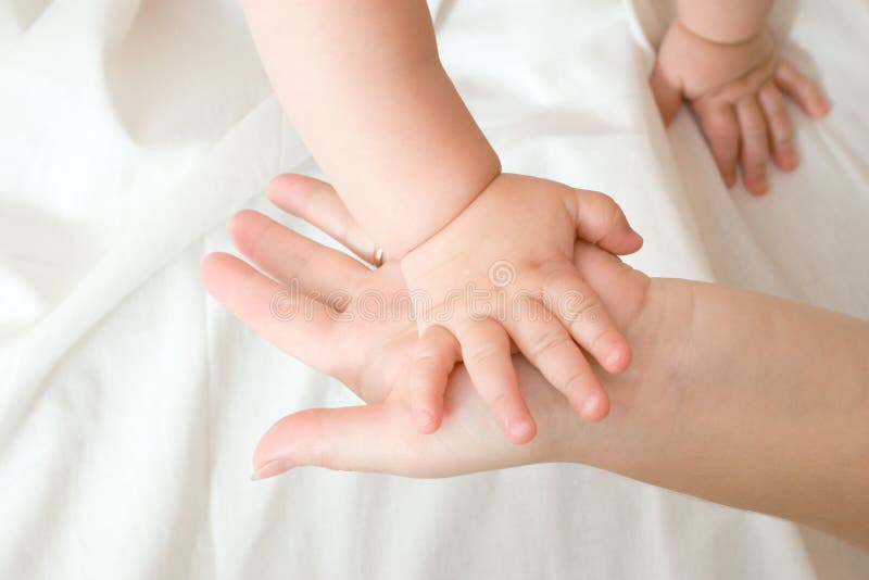 Hands of small baby and mother