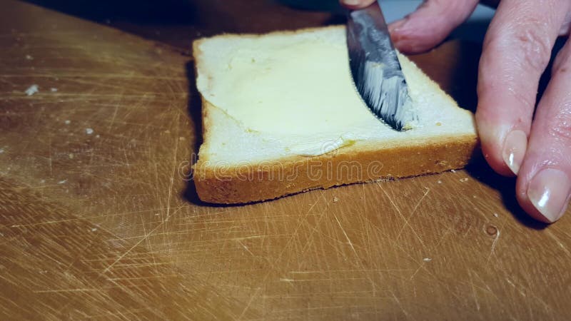 Hands smear butter on bread appetizer