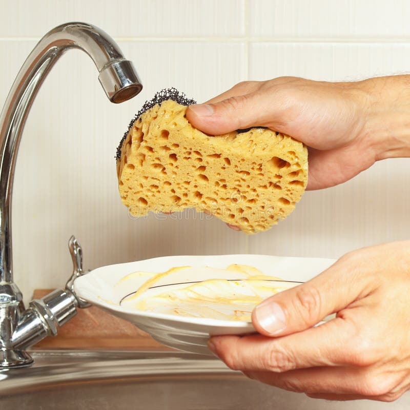 Hands with Sponge and Dirty Dishes Over the Sink in Kitchen Stock Photo
