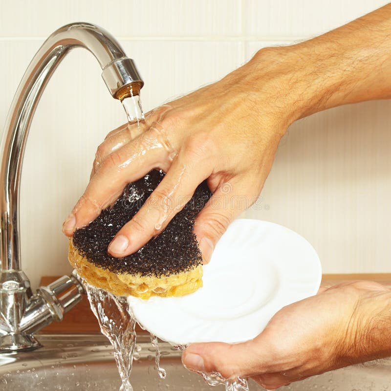 Hands with Sponge Wash the Dishes Under Running Water in Kitchen Stock