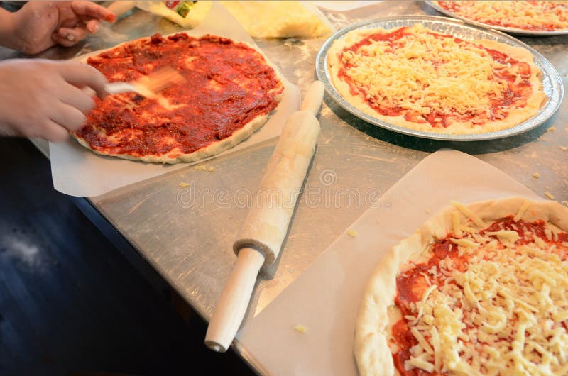 Hands Spreading Tomato Sauce on Pizza Base Stock Photo Image of