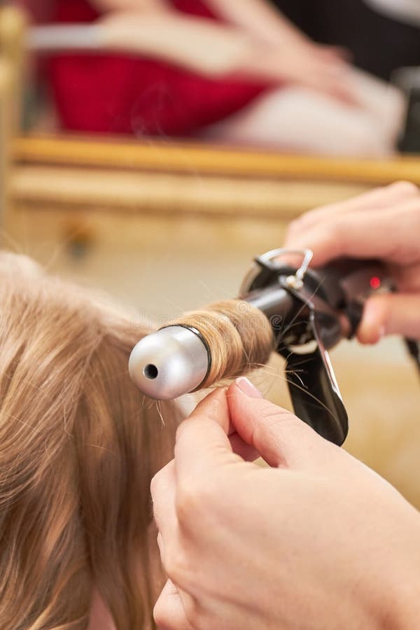 Stylist Curling Hair for Young Woman. Girl Care about Her Hairstyle. To Do Curls Stock Photo