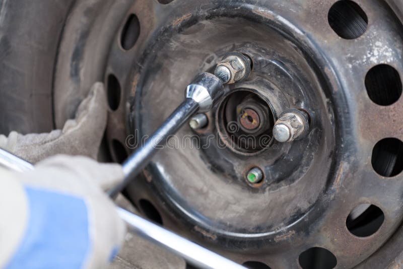 Hands Tightening the Screws of a Car Wheel Stock Photo Image of