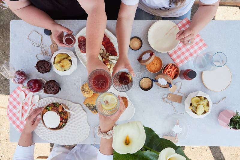 Hands Toasting at Table with Healthy Food and Drink Stock Image Image