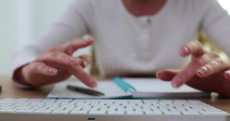 Hands typing on computer keyboard and notebook with note stock footage