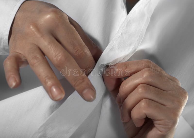 Hands of the woman unbuttoning a button on a white shirt. Button clasp stock images, royalty-free photos and pictures