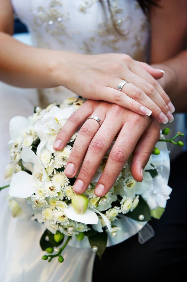 Hands with wedding gold rings and flowers