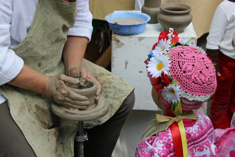 Hands working on pottery wheel and a little girl royalty free stock photography Hands working on pottery wheel and a little girl royalty free stock photography