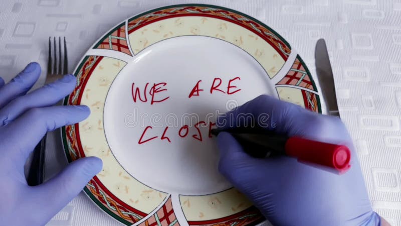 Hands write we and our restaurant is closed because Virus Covid 19