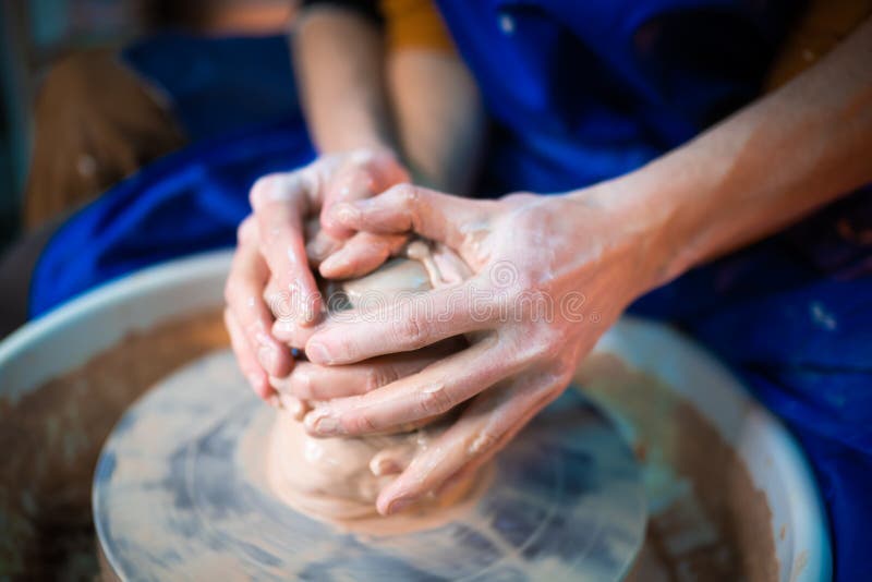 Hands of Young Couple in Love Making Clay Jug on Potter`s Wheel
