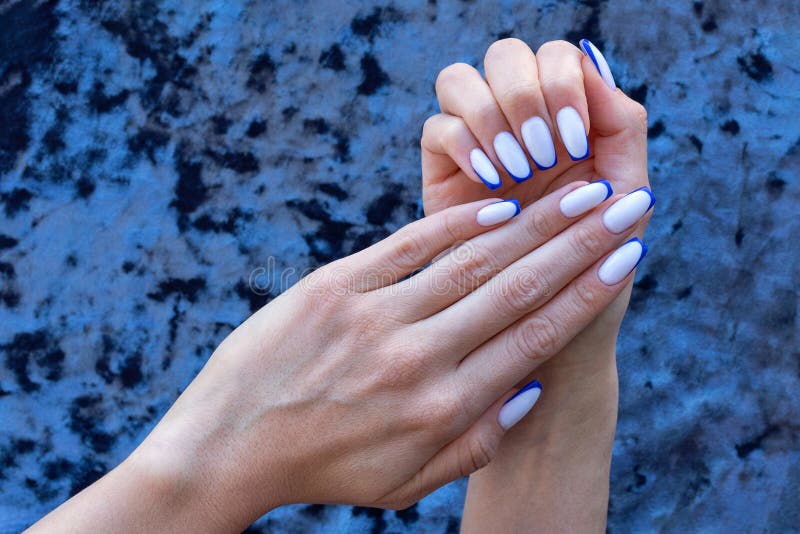 The Hands of a Young Woman with a French Manicure in White and Blue on ...