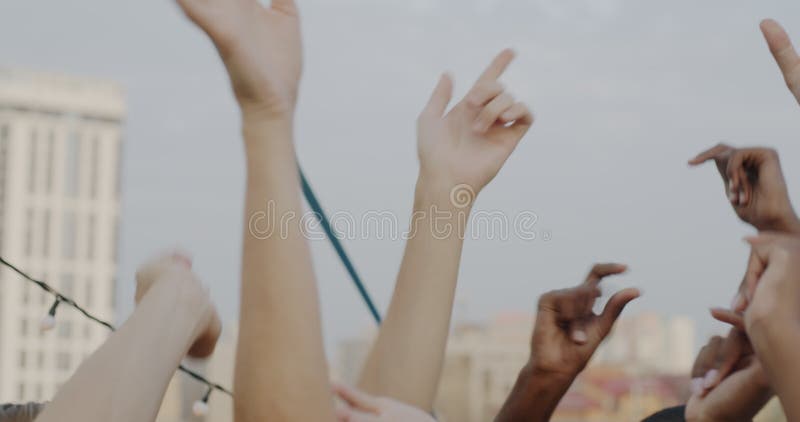 Handschließung mit Tätowierungen auf dem Dach, während die Leute verschiedene Gruppe Spaß Party