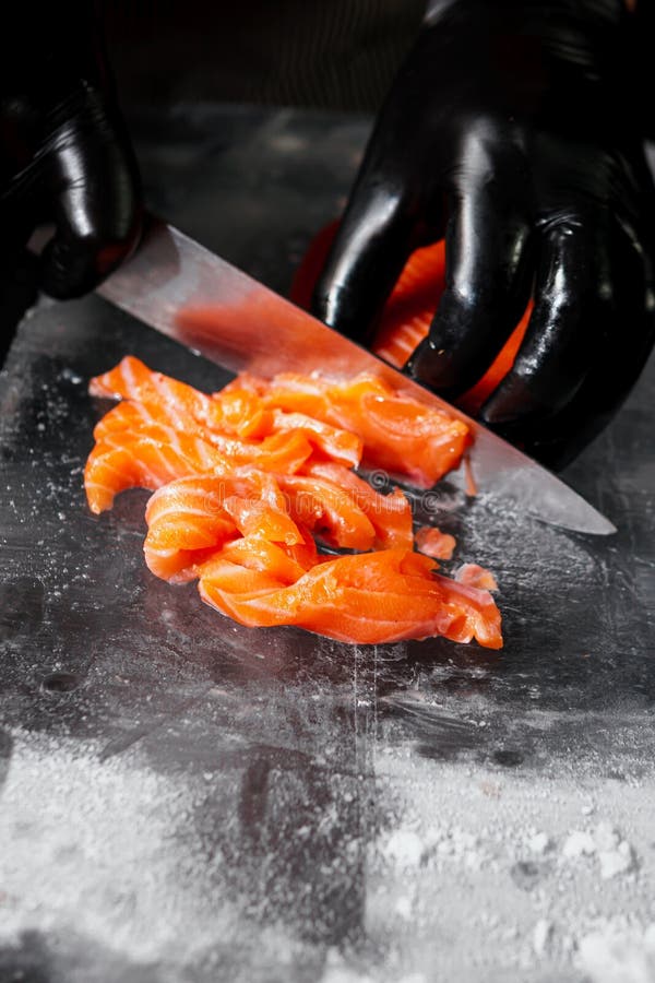 Handschließung, zubereitet zum Kochen von frischem Lachsfilet, schwarzer Hintergrund lizenzfreie stockfotos