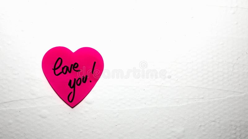 Handwriting text love you on heart shaped memo post reminder. Romantic love concept for Valentine`s day. Handwriting text love you on heart shaped memo post reminder. Romantic love concept for Valentine`s day