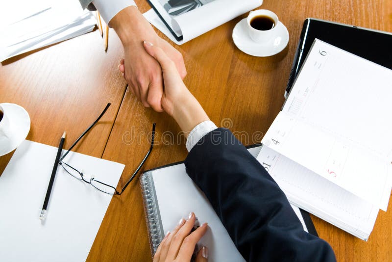 Image of handshake of partners over table with business objects on it. Negotiating table stock images, royalty-free photos and pictures