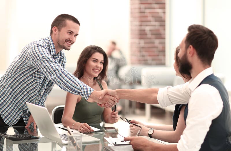 Handshake business partners over the Desk in the office.concept of cooperation