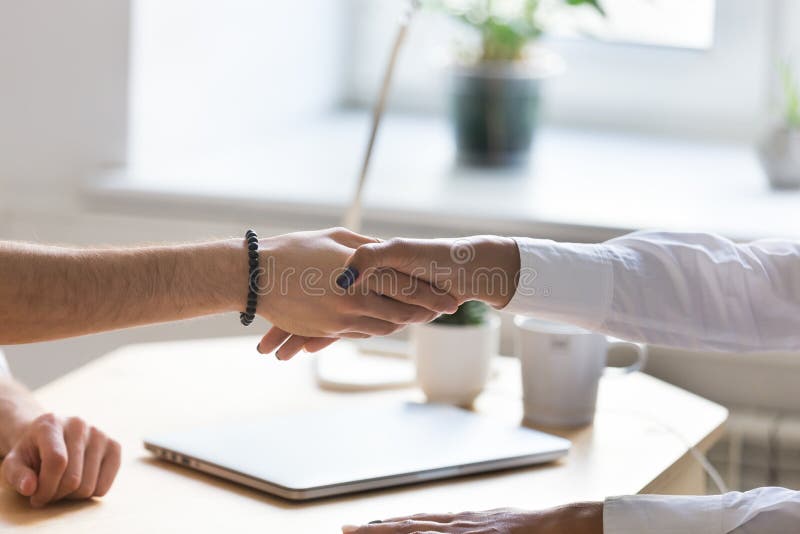 Handshake multirazziale della donna di affari e dell'uomo d'affari alla riunione fotografia stock libera da diritti Handshake multirazziale della donna di affari e dell'uomo d'affari alla riunione fotografia stock libera da diritti