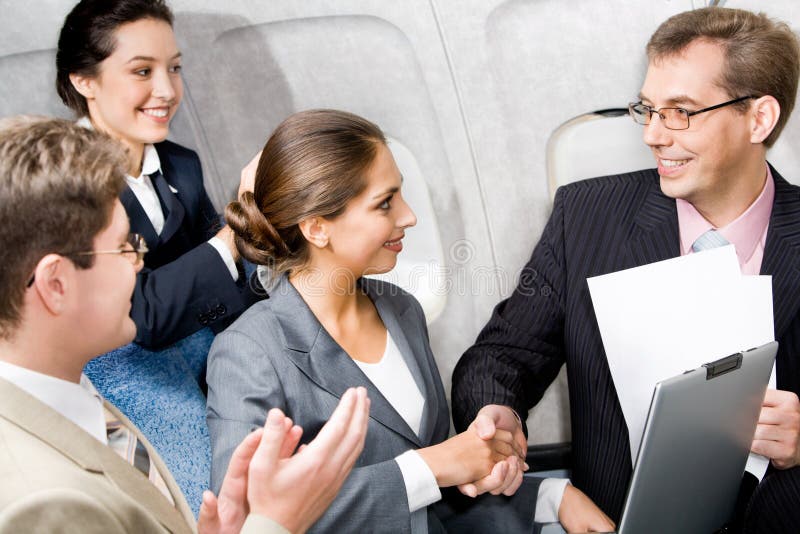 Business people shaking hands making an agreement in the plane. Business people shaking hands making an agreement in the plane