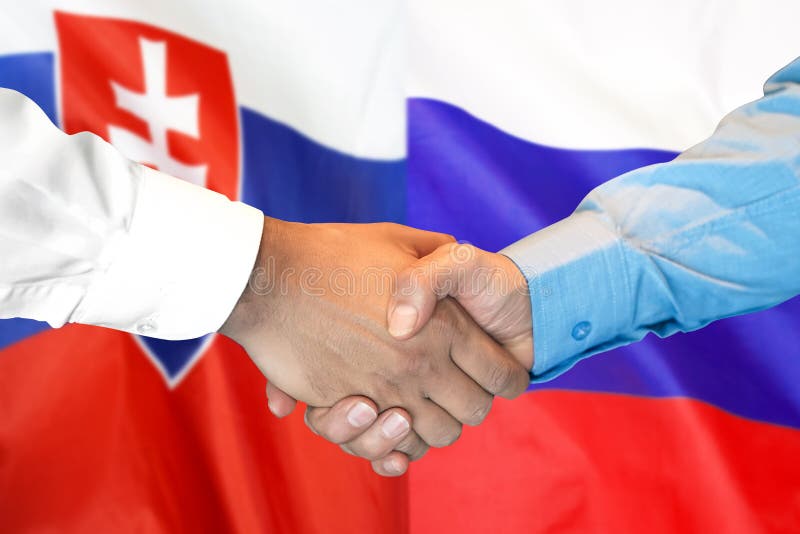 Potřesení rukou na pozadí vlajky Slovenska a Ruska
