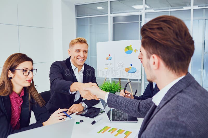 Handshake of young businessmen at a meeting of partners in an office. royalty free stock photos Handshake of young businessmen at a meeting of partners in an office. royalty free stock photos