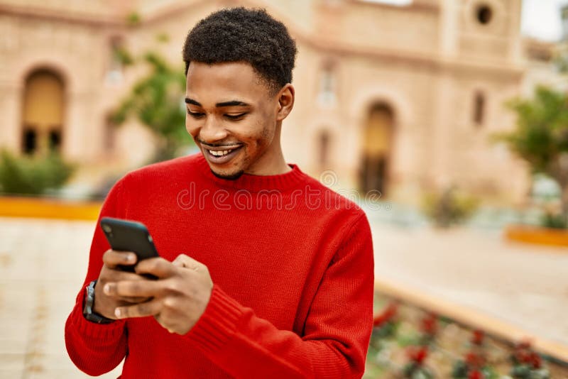 Handsome african american man outdoors using smartphone typing a message stock images