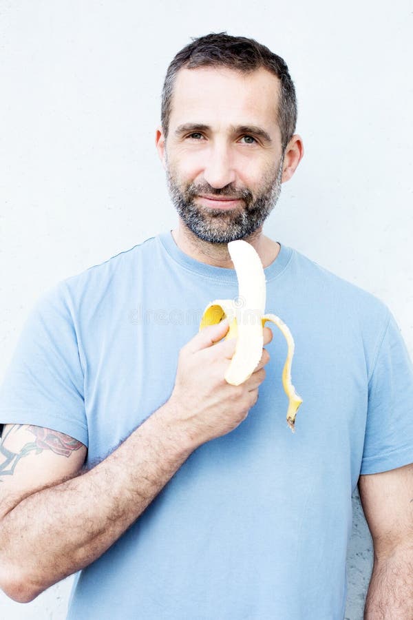 Handsome Bearded Man Eating a Banana Stock Photo Image of model
