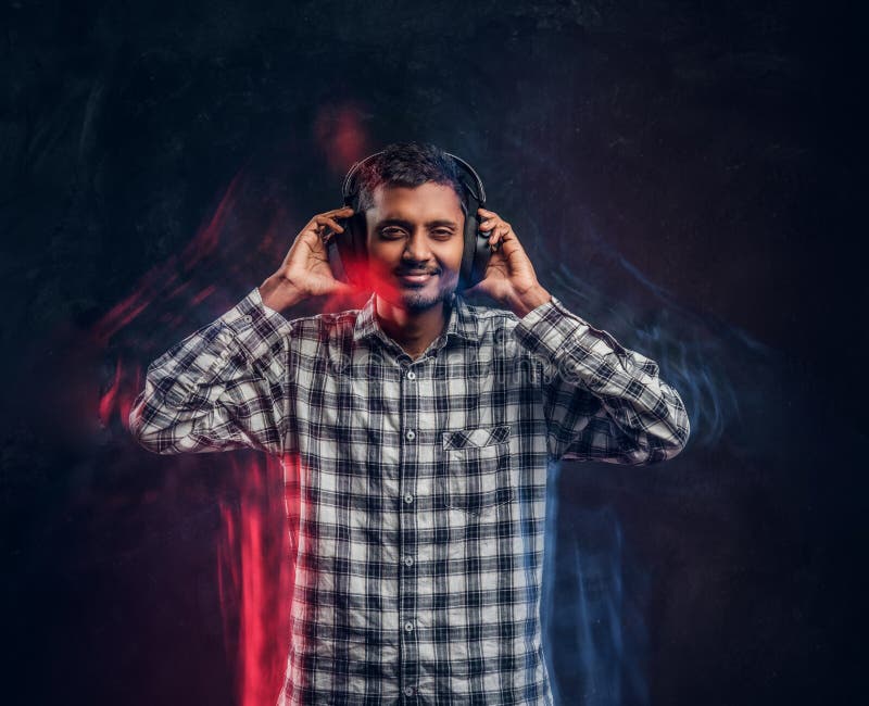Handsome black guy smiles, listens to soul music in headphones