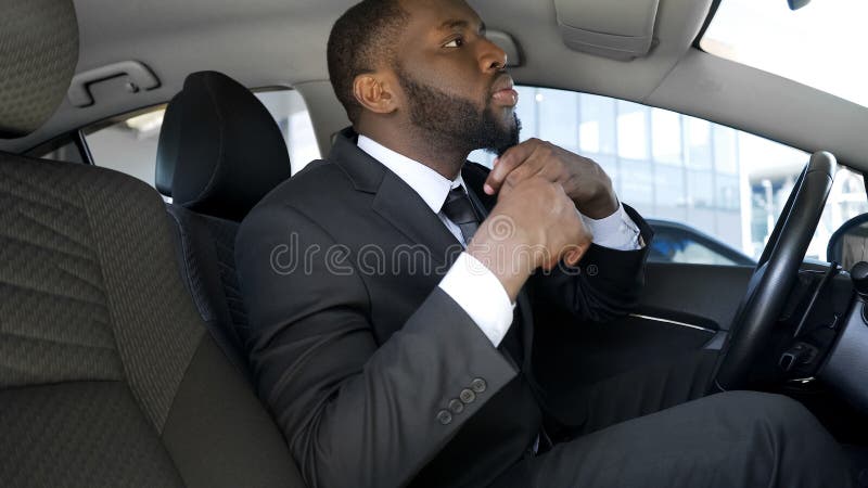 Handsome black man in business suit looking in car mirror, ready for date royalty free stock images Handsome black man in business suit looking in car mirror, ready for date royalty free stock images