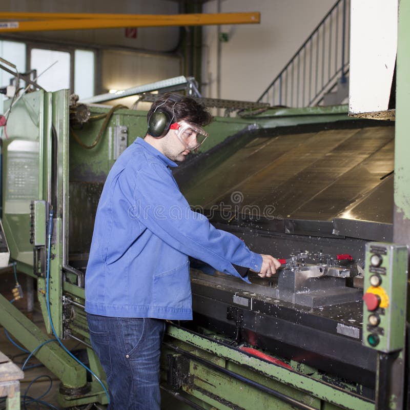 Handsome blue collar worker in factory stock image