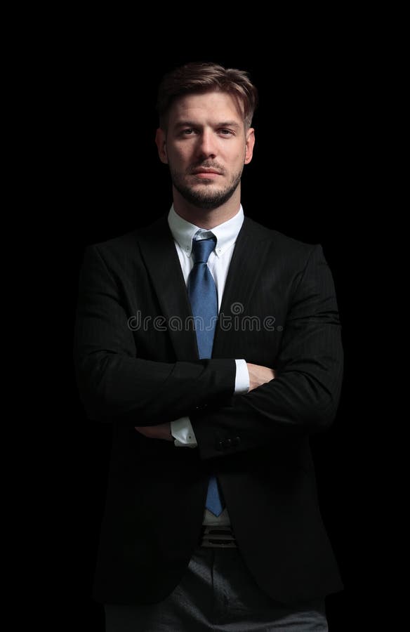 Handsome business man isolated on black with arms crossed