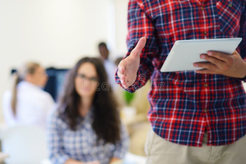 Handsome businessman with open hand ready for handshake in startup office royalty free stock image Handsome businessman with open hand ready for handshake in startup office royalty free stock image