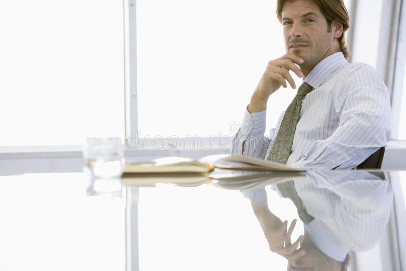 Portrait of handsome young businessman sitting at conference table. Portrait of handsome young businessman sitting at conference table