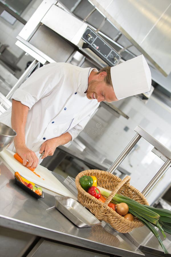 Handsome chef preparing salad in restaurant kitchen stock photo Handsome chef preparing salad in restaurant kitchen stock photo
