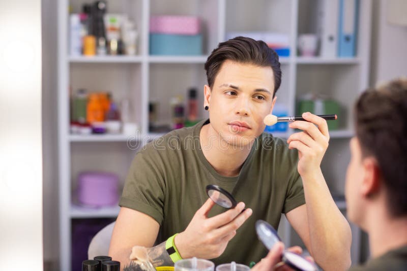 Handsome Darkhaired Young Guy Applying Makeup on the Face Stock Image
