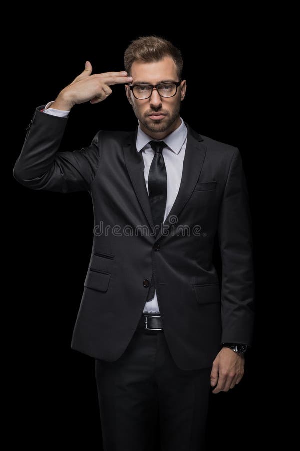 Handsome depressed businessman in black suit with hand gun sign stock image Handsome depressed businessman in black suit with hand gun sign stock image